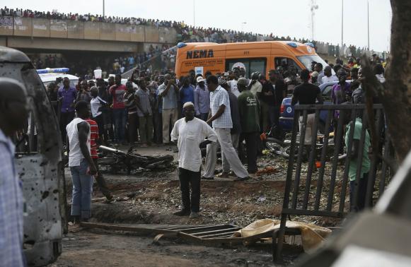 Crowd gather at the scene of a bomb blast at a bus terminal in Nyayan, Abuja April 14, 2014. A morning rush hour bomb killed at least 71 people at a Nigerian bus station on the outskirts of the capital on Monday, raising concerns about the spread of an Islamist insurgency after the deadliest ever attack on Abuja. Suspicion fell on Boko Haram, though there was no immediate claim of responsibility from the Islamists who are mainly active in the northeast. As well as 71 dead, police said 124 were wounded in the first attack on the federal capital in two years. REUTERS/Afolabi Sotunde (NIGERIA - Tags: CIVIL UNREST)