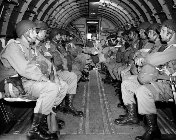 American paratroopers, heavily armed, sit inside a military plane as they soar over the English Channel en route to the Normandy French coast for the Allied D-Day invasion of the German stronghold during World War II, June 6, 1944. (AP Photo)