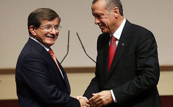 Turkey's president-elect Recep Tayyip Erdogan (R) shakes hands with Turkey's Foreign Minister Ahmet Davutoglu after he announced Davutoglu as the new Turkish prime minister