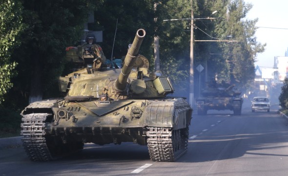 Pro-Russian rebels ride on a tank in eastern Ukraine on Saturday, August 23, 2014. (AP Photo)