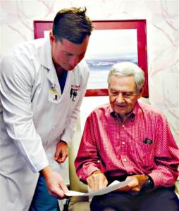 Dr. Robert Kincade (left) shows Dr. Jim Affleck his birth certificate.