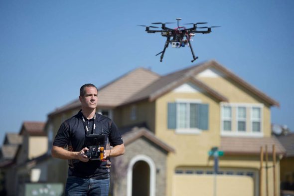 Christopher Brown, co-owner of Next New Homes Group, uses his multi-rotor helicopter drone to take aerial video... 