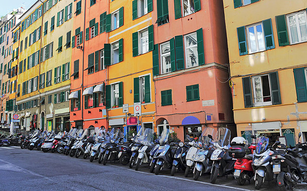 Motorbikes, many of them Vespas, line the street in Genoa (Photo: Alamy)