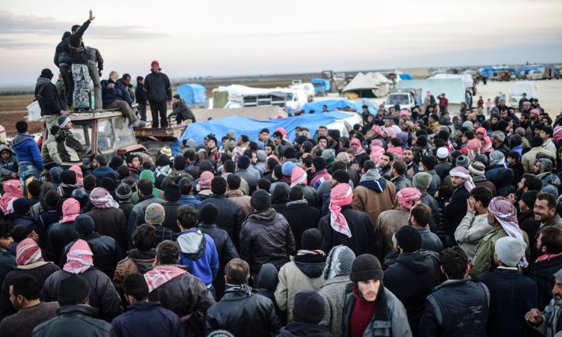 Syrians gather at the Bab al-Salam border gate with Turkey, in Syria, Saturday, Feb. 6, 2016.
