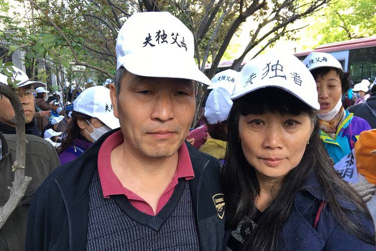 Jie Dongsheng and his wife, Li Xurong, stand amid hundreds of bereaved parents who have lost their only children and are seeking government benefits to support them in their retirement.