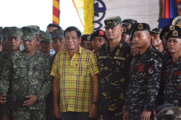 Philippine President Rodrigo Duterte (centre L) poses for photos with military personnel during a visit to a military camp in the town of Jolo, Sulu province, in the southern island of Mindanao on August 12, 2016. Philippine President Rodrigo Duterte on August 12 refused to apologise for calling the US ambassador "gay" and "the son of a whore" in remarks that sparked a diplomatic row. / AFP / STR (Photo credit should read STR/AFP/Getty Images) 