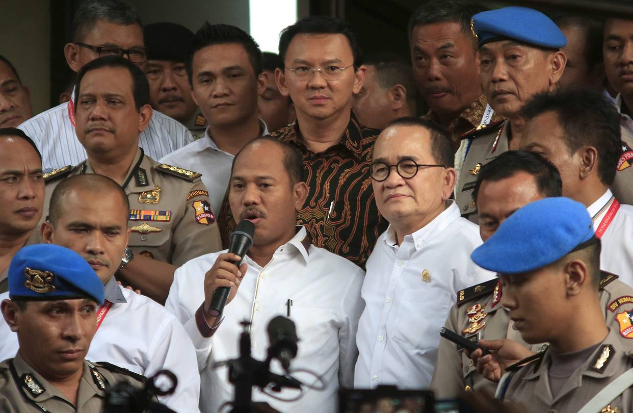 Indonesia's Christian governor Ahok (top, center) leaving the police station Monday.