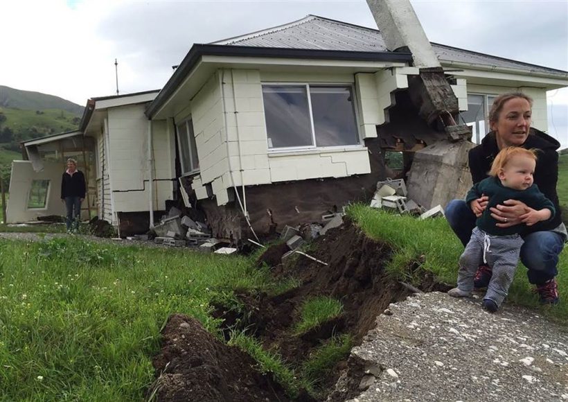 A woman and child in front of a house damaged by the earthquake near Kaikoura.