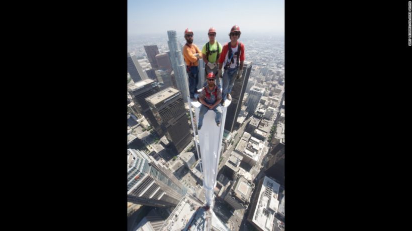 Construction workers pose at top of skyscraper