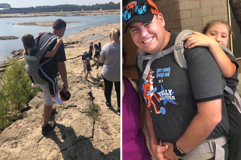 Teacher carries student with spina bifida on outdoor field trip